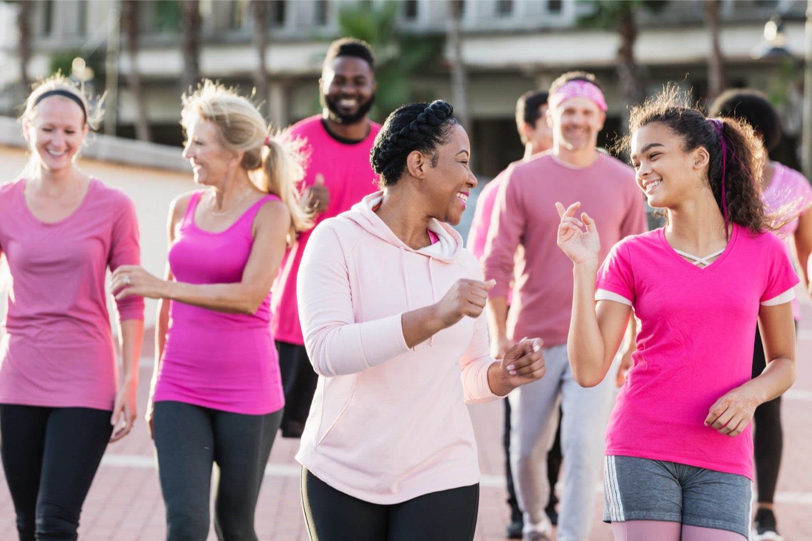 Group of people smiling and wearing pink