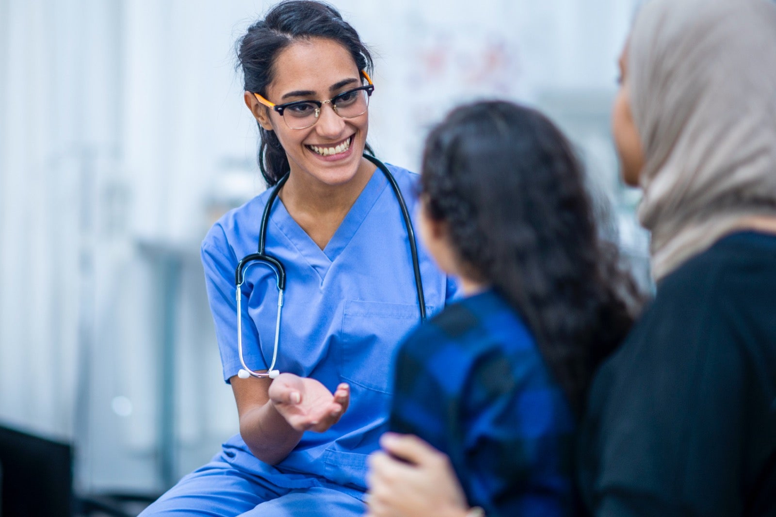 Happy doctor speaking to woman and child.