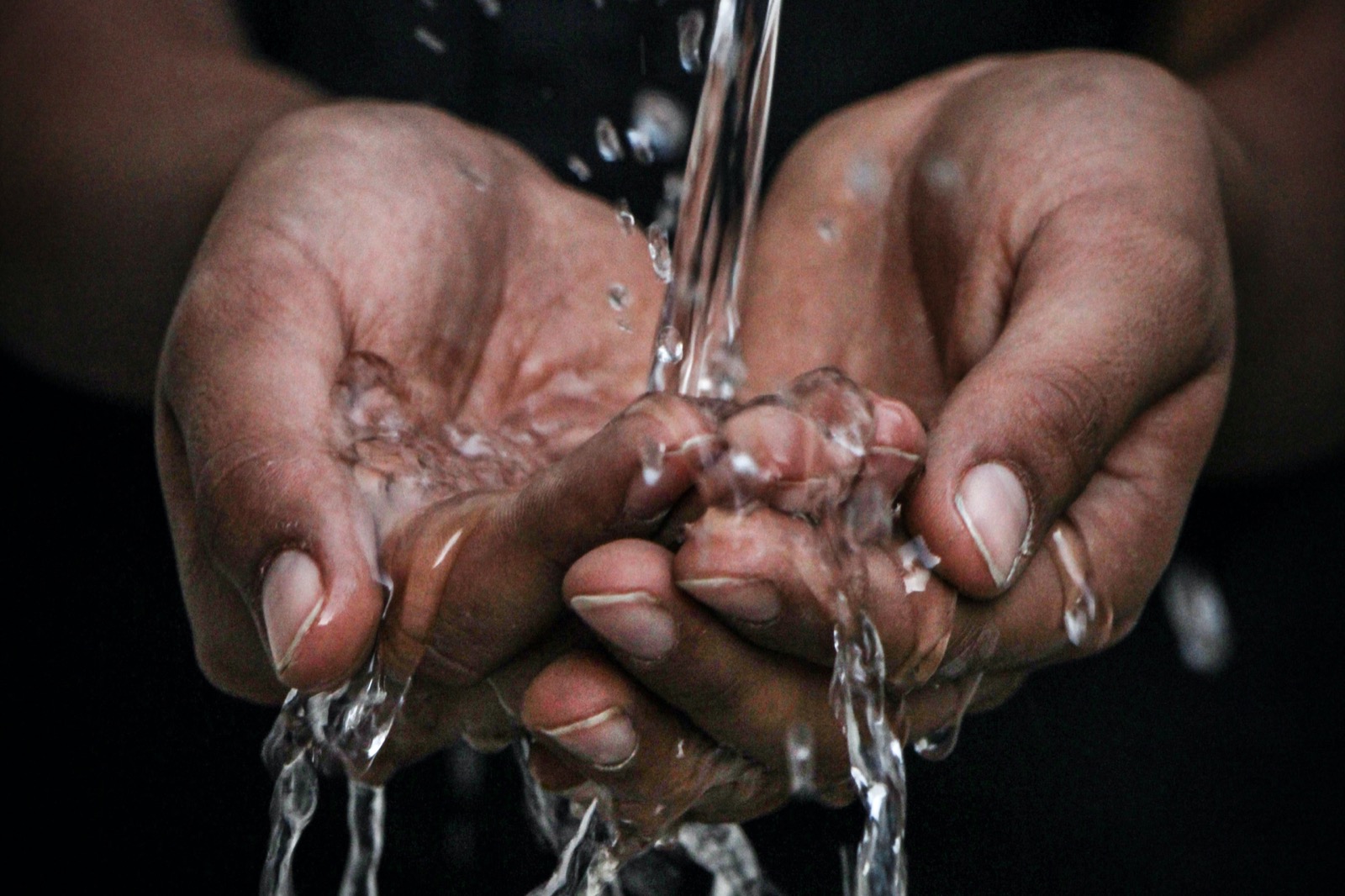 Hands together with water washing over them.