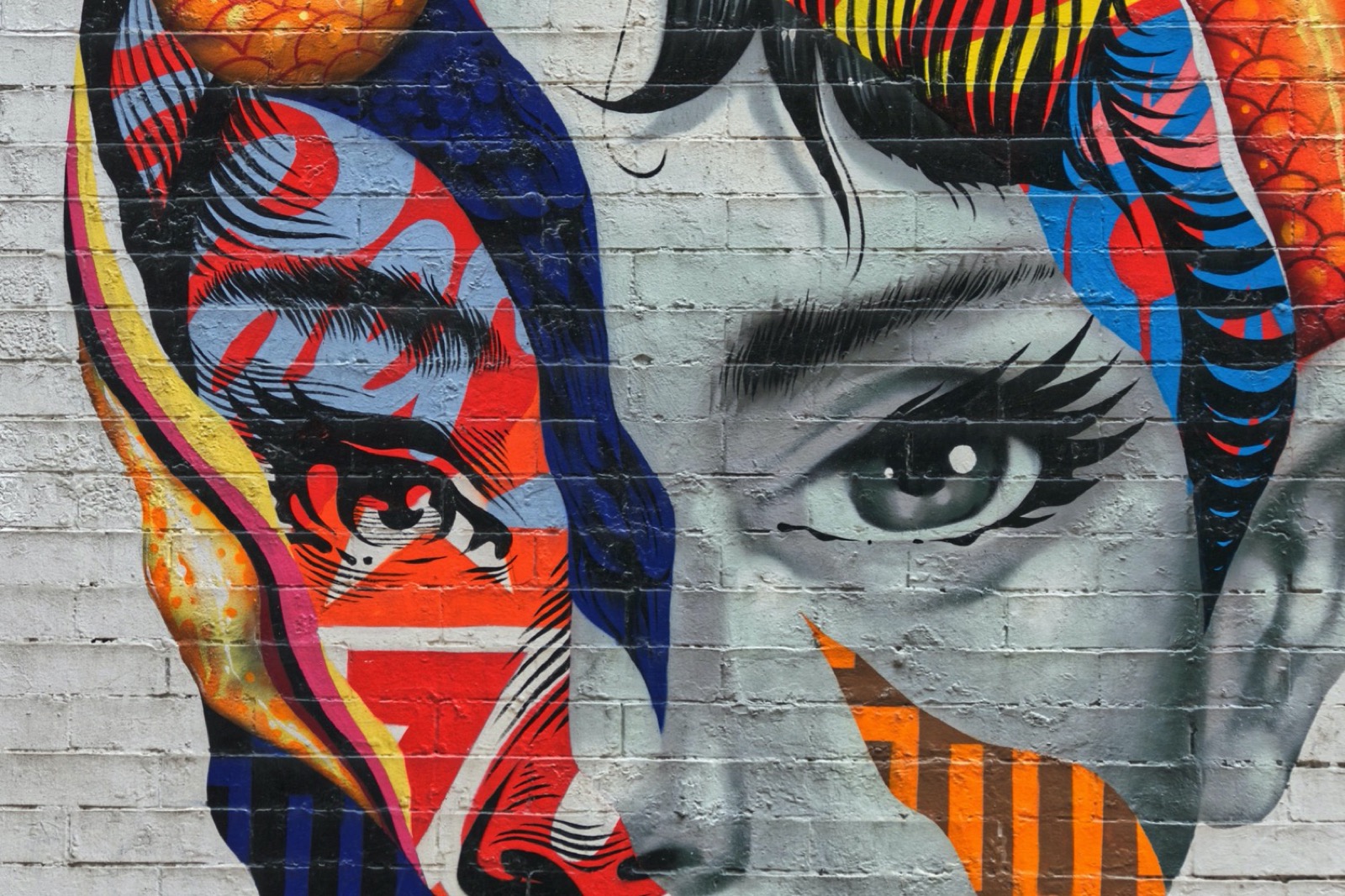 Colorful collage of woman's face on wall.