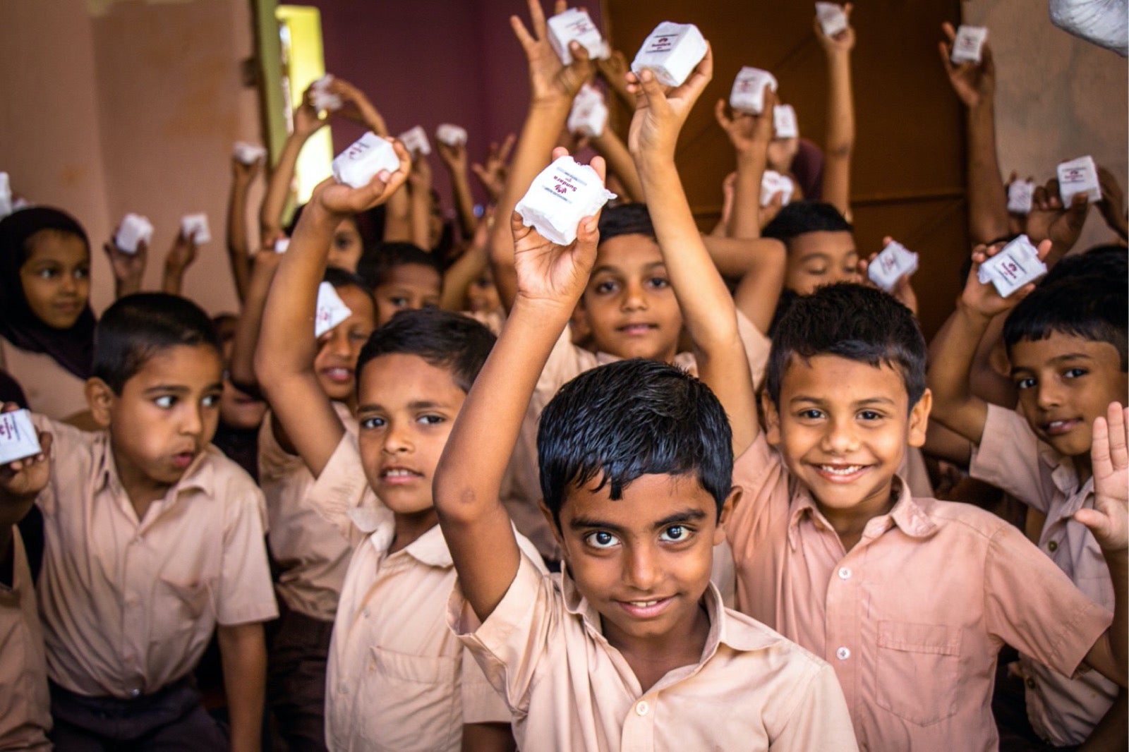 Happy children holding white boxes.